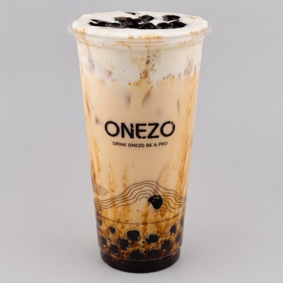 ONEZO-branded milk tea with tapioca pearls, caramel swirls, whipped cream, and chocolate drizzle in a clear cup.