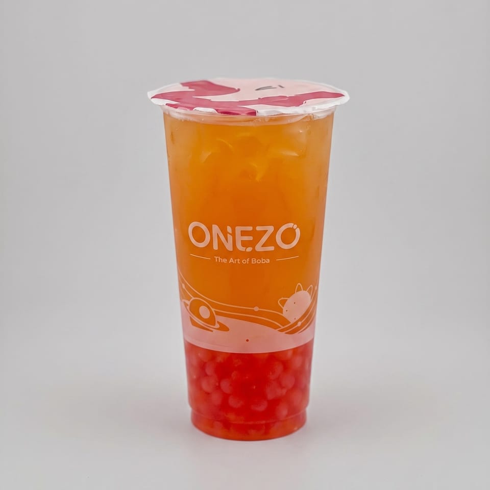OneZo boba tea cup filled with orange-colored drink, red tapioca pearls, ice, and a sealed lid.