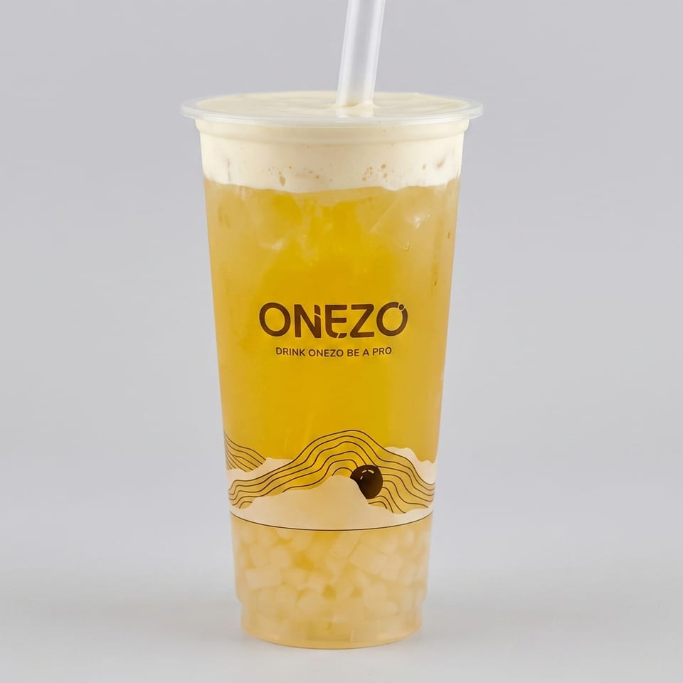 Onezo-branded clear cup containing a bright yellow iced drink with creamy foam, tapioca pearls, sealed lid, and straw.
