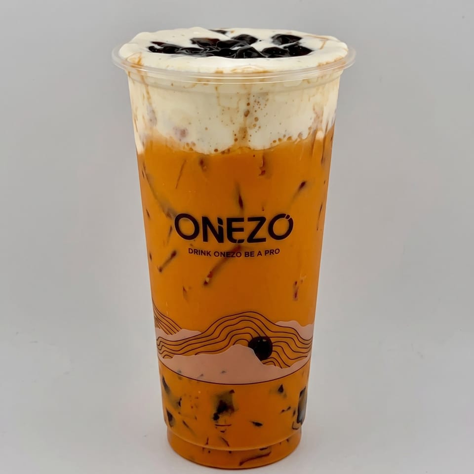 ONEZO branded orange iced drink in a clear cup, topped with whipped cream and dark syrup.